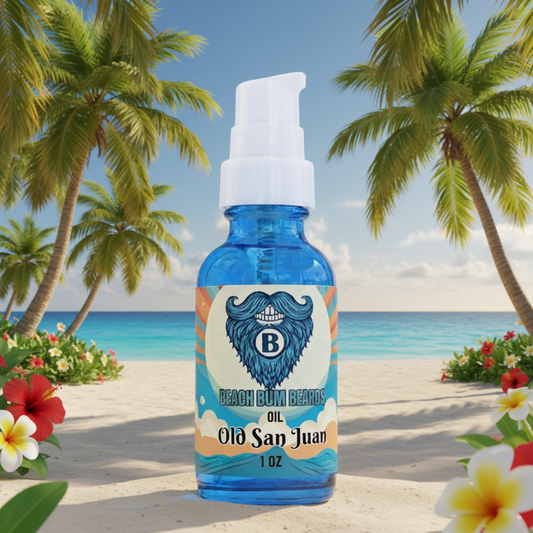 A 1 oz bottle of 'Old San Juan' Beach Bum Balm oil stands on a sandy beach with palm trees and turquoise water in the background. The bottle is translucent blue with a white pump dispenser and a label featuring a blue mustache logo and the text 'BEACH BUM BARM OIL Old San Juan 1 OZ'.